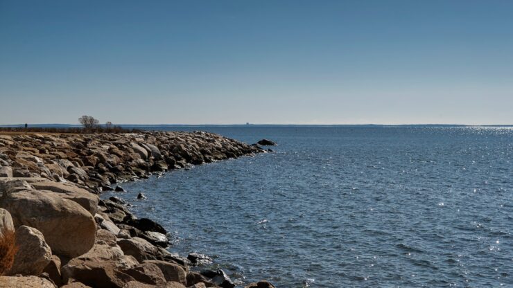 A stone jetty at sherwood island state park in Westport, Connecticut on a sunny day.