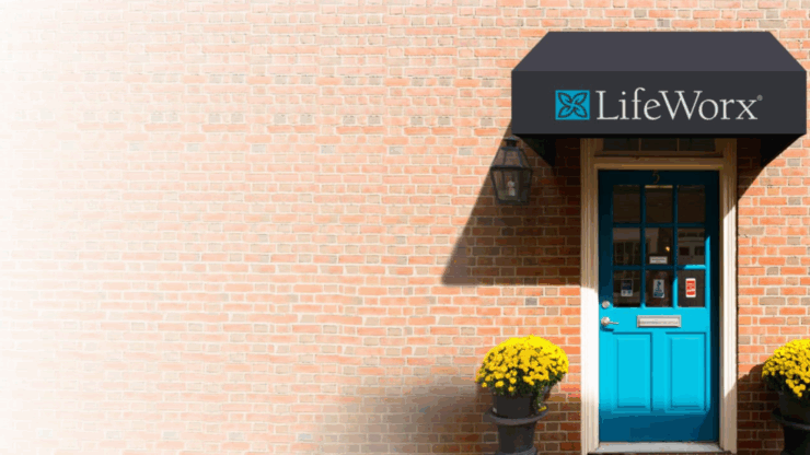 Red brick building with a turquoise door and black awning displaying