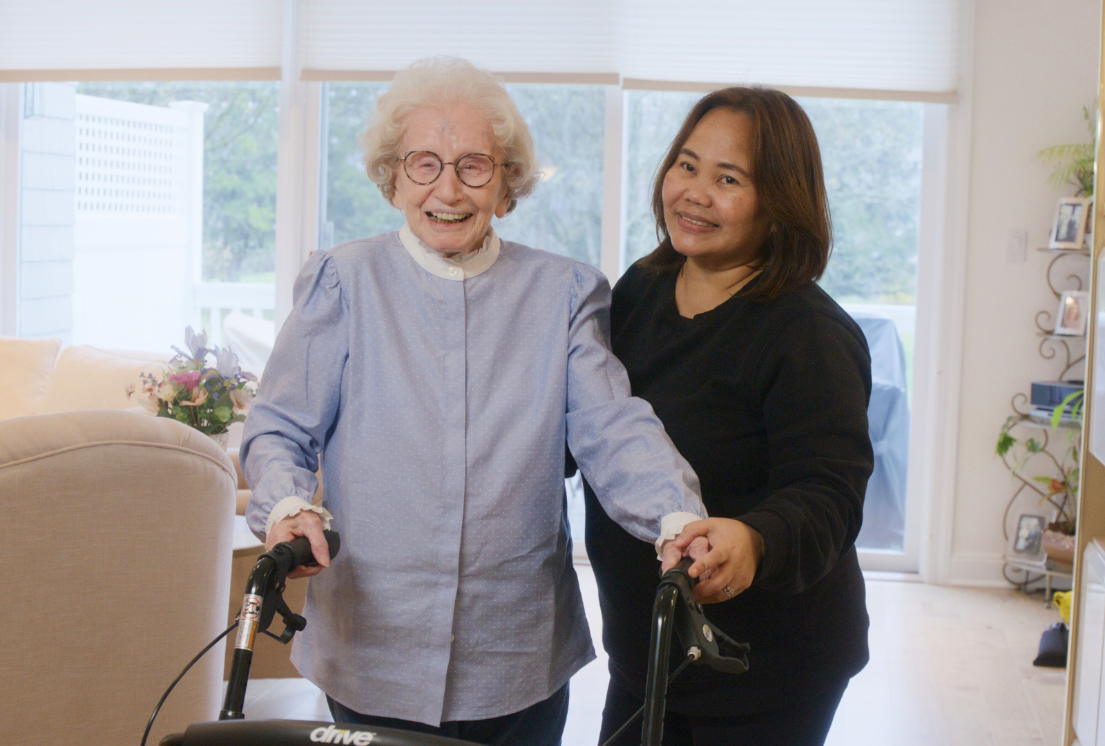 Ecstatic smiling senior woman with her smiling caregiver, enjoying companionship