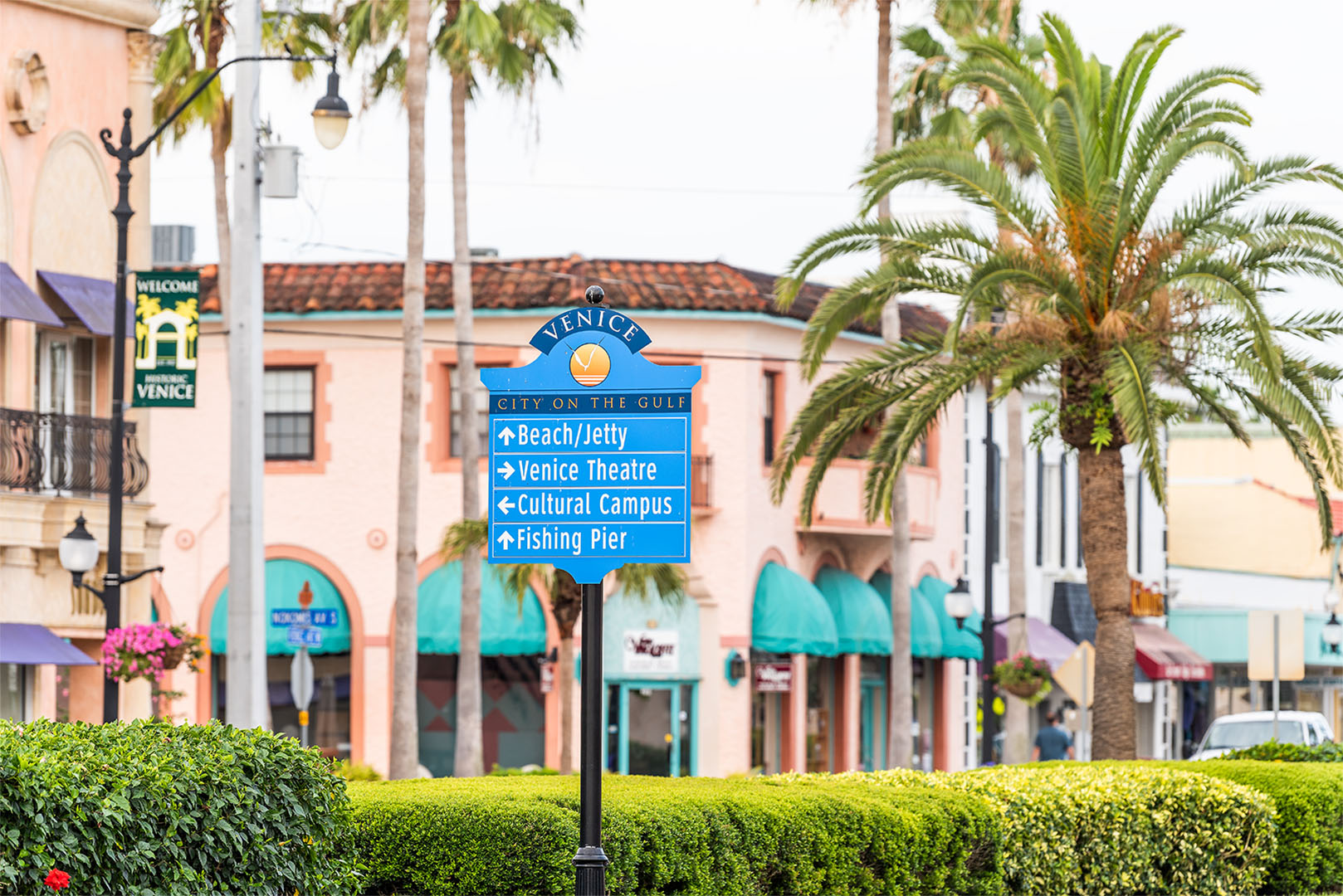 Directional sign in downtown Venice, Florida pointing to beach, theatre, cultural campus, and fishing pier.
