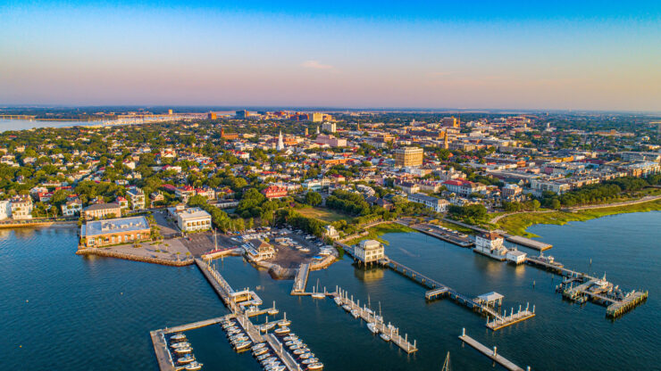 Aerial view of Charleston, South Carolina, showing a marina, buildings, and clear skies.